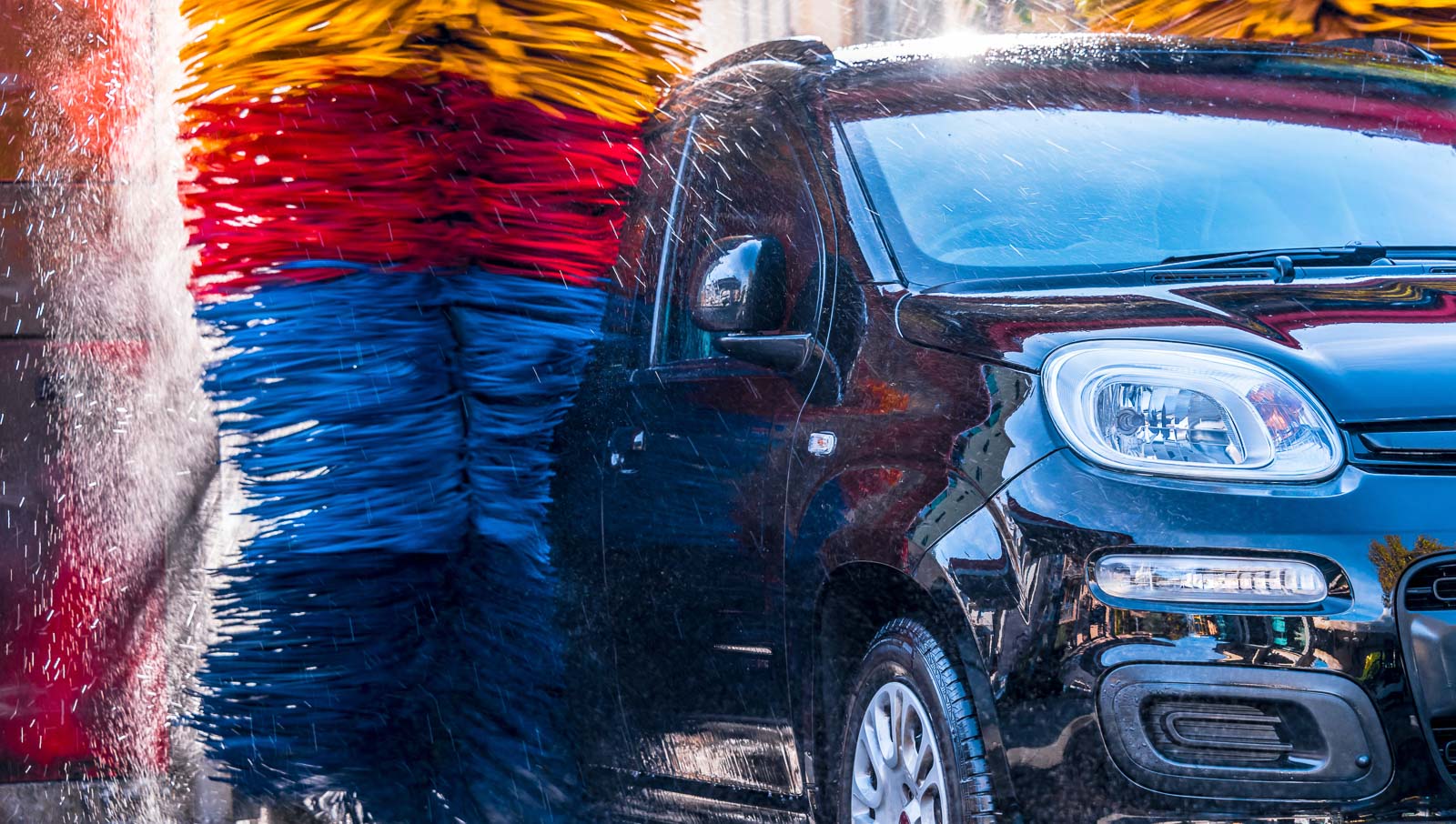 Black sport car wheel detail covered with shampoo ready to clean. Car Tire or alluminium wheel wash. banner